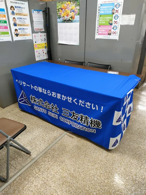 左右に格子柄を使用しためねじ補強材の専門商社のテーブルクロスを製作しました!