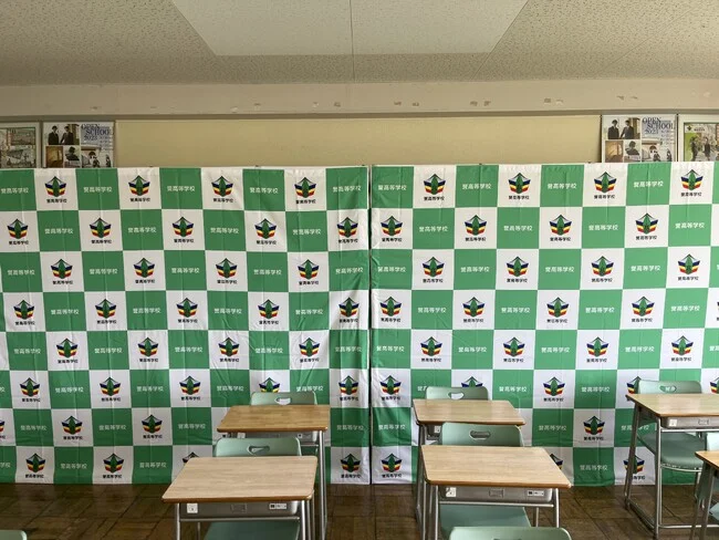 緑が教室に映える学校名と校章の格子柄のバックパネルを製作しました！