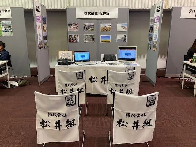 白地に力強い筆文字が映える建設業者様のテーブルクロス・椅子カバーを製作いたしました。