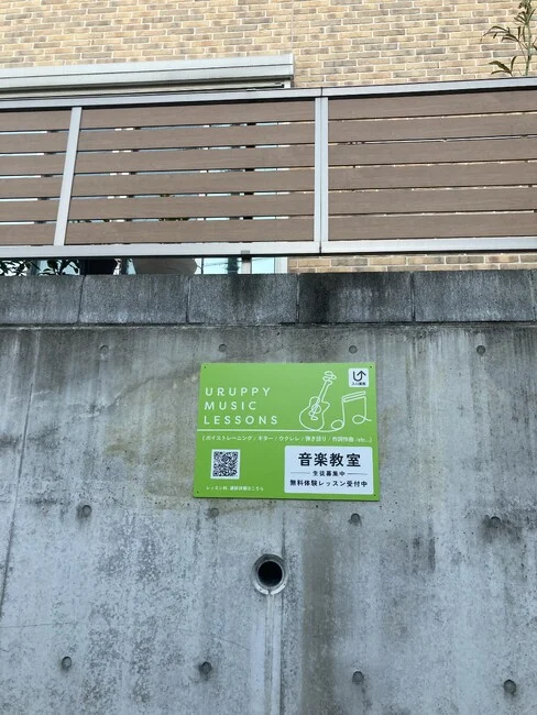 発色の良い黄緑色にピアノとギターのラインアートが目を引く音楽教室の店舗看板を製作いたしました。